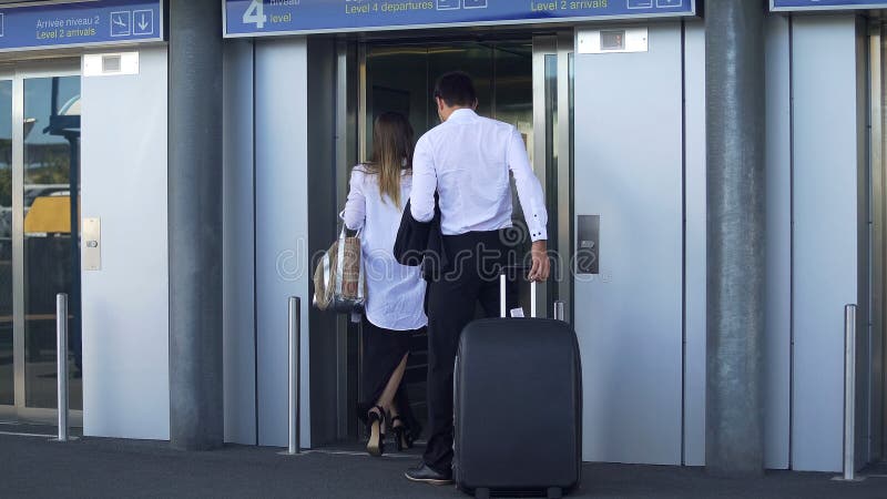 Young couple entering elevator at airport, business trip, travel and tourism royalty free stock images Young couple entering elevator at airport, business trip, travel and tourism royalty free stock images