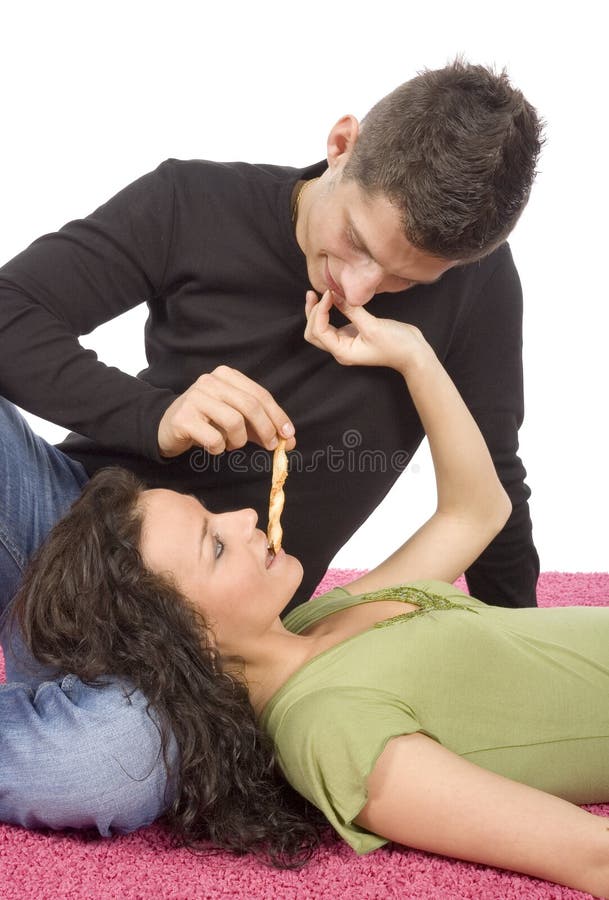 Young couple feeding each other roll cake