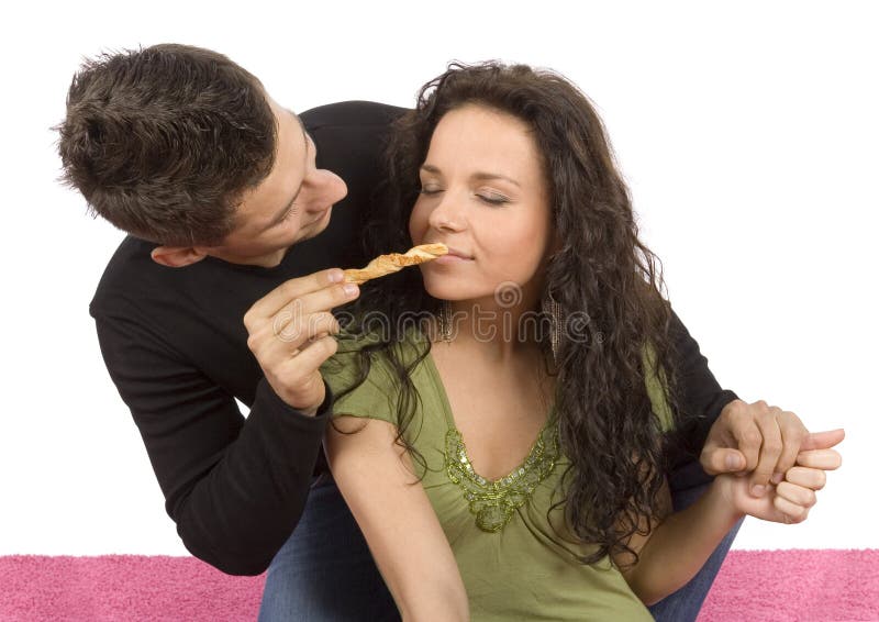 Young couple feeding each other roll cake