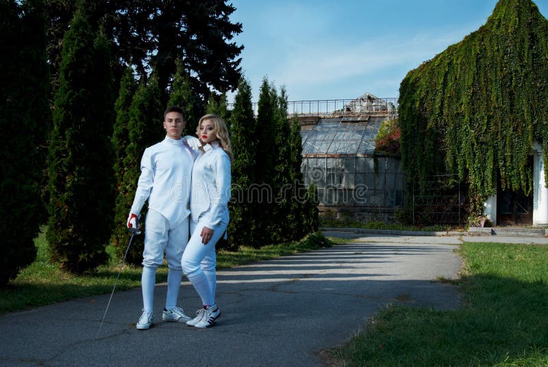 Young couple in fencing costumes