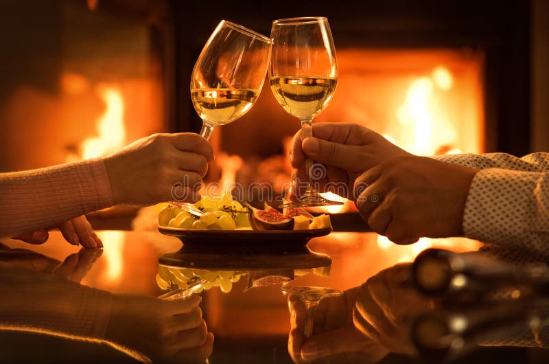 Young Couple Have Romantic Dinner with Wine Over Fireplace Background