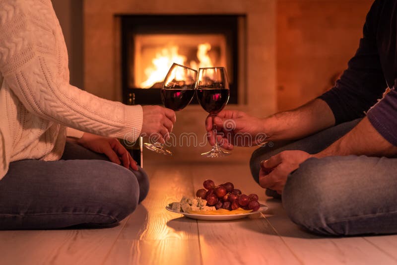 Young couple have romantic dinner with wine over fireplace background. royalty free stock photo Young couple have romantic dinner with wine over fireplace background. royalty free stock photo