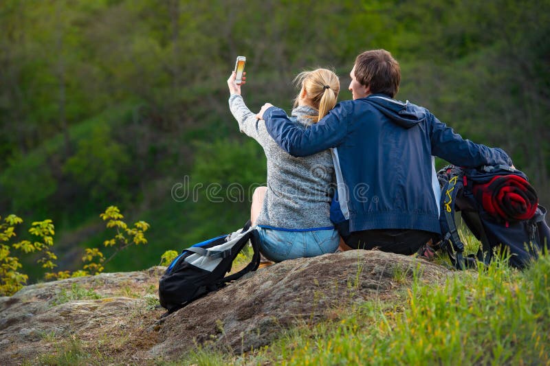 Young couple hikers resting and enjoying beautiful nature view a royalty free stock photo Young couple hikers resting and enjoying beautiful nature view a royalty free stock photo