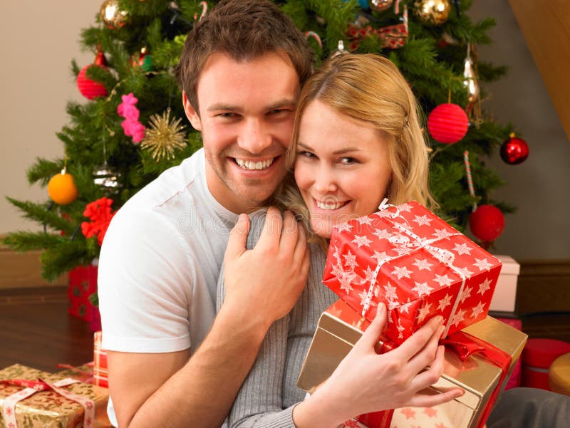 Young Couple in home exchanging gifts stock image Young Couple in home exchanging gifts stock image