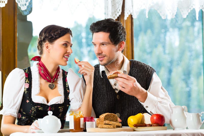 Young couple in a hunter's cabin eating stock images Young couple in a hunter's cabin eating stock images