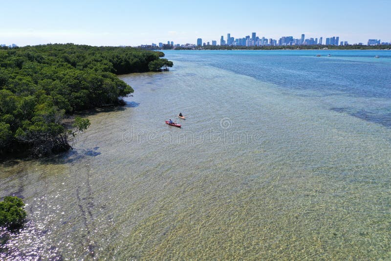 Young couple kayaking on Bear Cut off Key Biscayne, Florida on sunny afternoon.