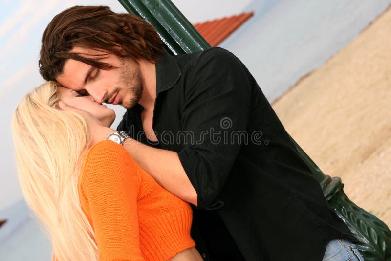 A young couple in love kissing outdoors. A young couple in love kissing outdoors