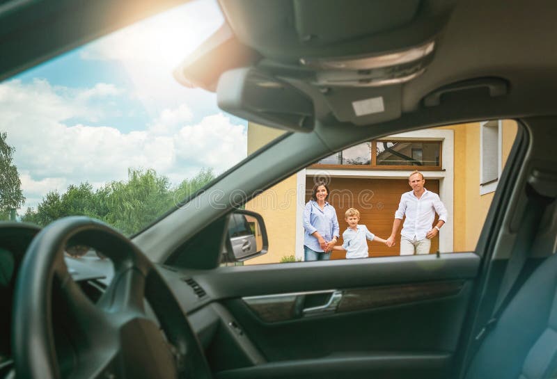 Young couple with little boy son goes to their new car standing on the new home yard inside car view