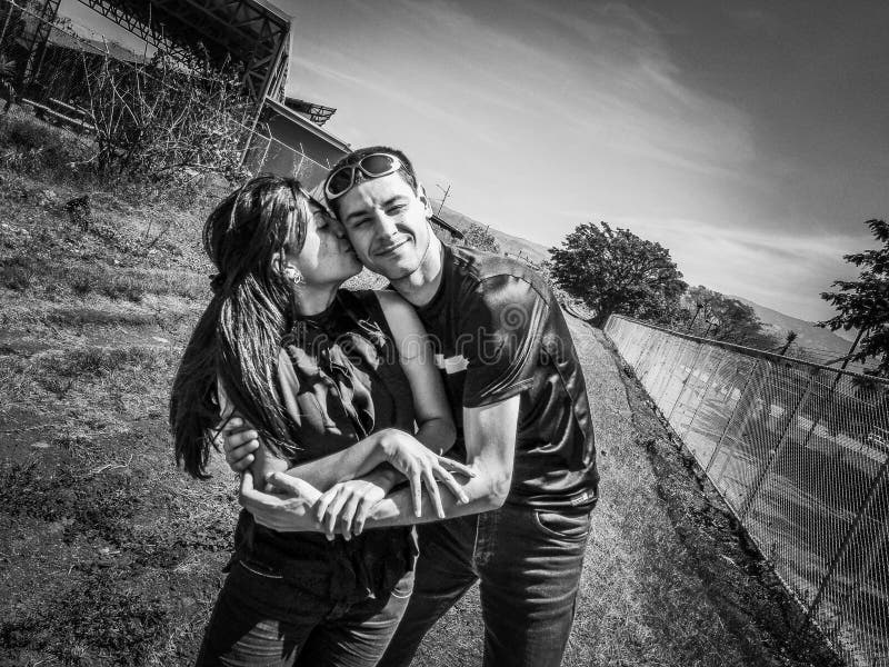 Happy young romantic couple in love embracing and kissing in a field. royalty free stock photo