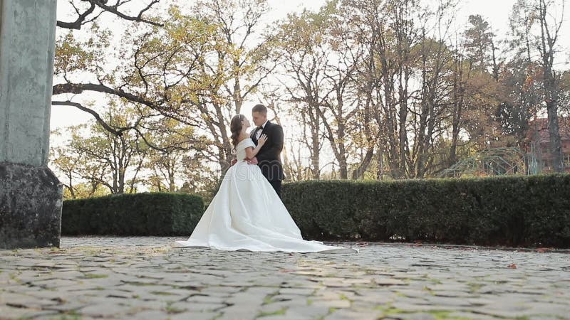 Young couple in love at sunset, they embrace kiss and look at each other with tenderness. Cheerful wedding couple