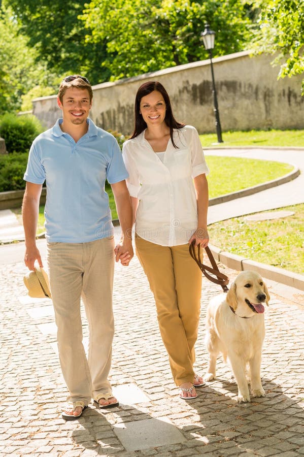 Young couple in love walking dog park royalty free stock photography Young couple in love walking dog park royalty free stock photography