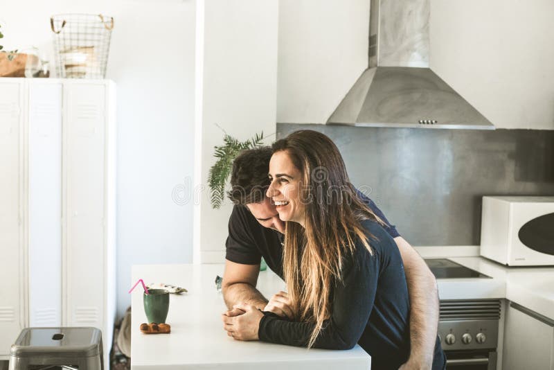 The Lovers Getting Hot In The Kitchen Young Couple of Lovers Kissing and Hugging in the Kitchen. Man and