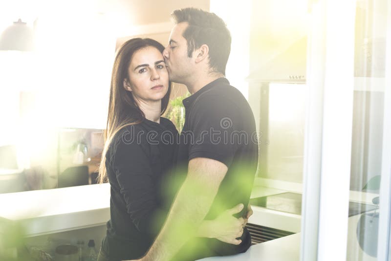 The Lovers Getting Hot In The Kitchen Young Couple of Lovers Kissing and Hugging in the Kitchen. Man and