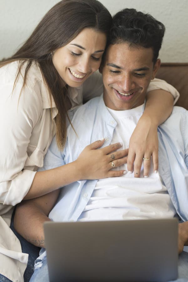 Young couple moving to a new home relaxing sitting on the sofa using computer laptop, smiling happy for moving to new apartment stock photos