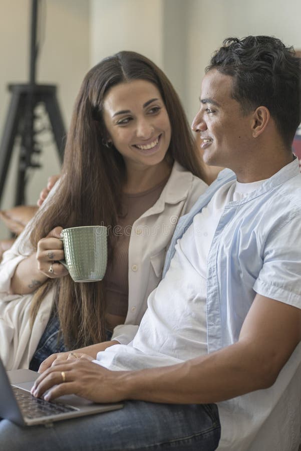 Young couple moving to a new home relaxing sitting on the sofa using computer laptop, smiling happy for moving to new apartment stock photos