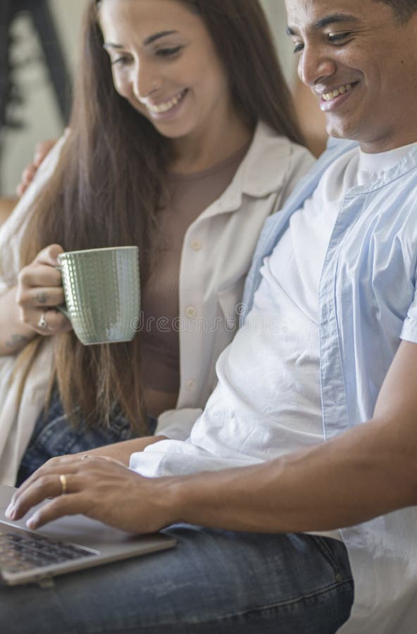 Young couple moving to a new home relaxing sitting on the sofa using computer laptop, smiling happy for moving to new apartment stock photo