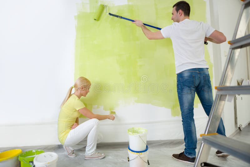 Young couple painting wall