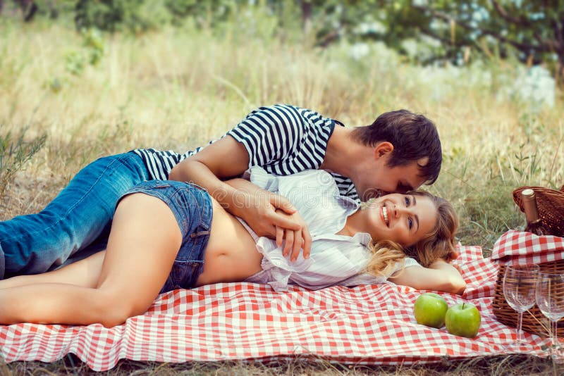 Young couple on picnic. lying embrace.