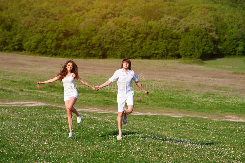 Young couple playing on the meadow royalty free stock image