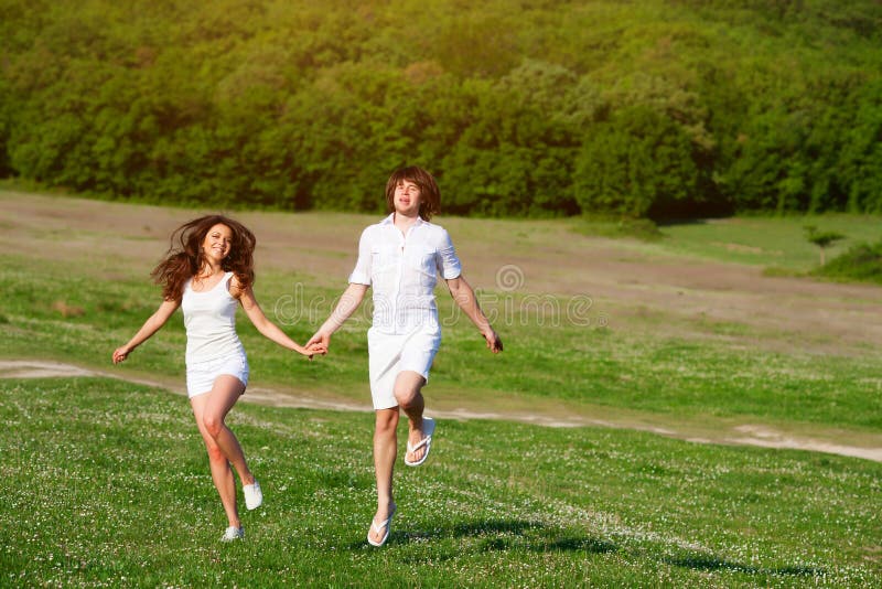 Young couple playing on the meadow royalty free stock images