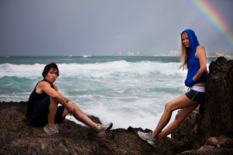 Young Couple Posing on Rocks By Stormy Ocean