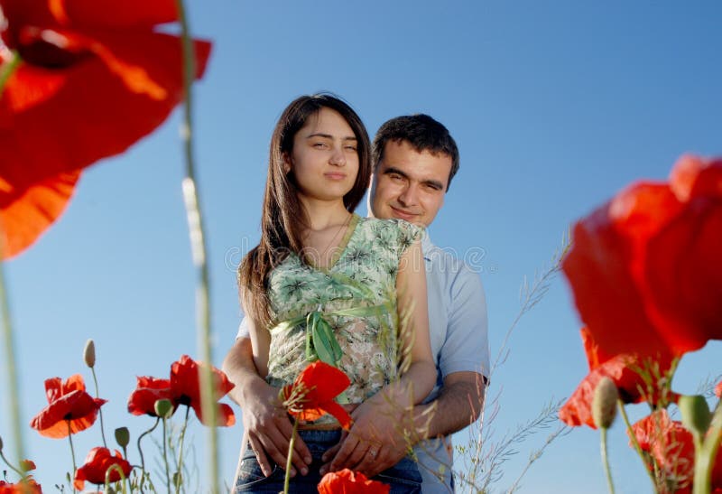 Young couple on a red poppies field