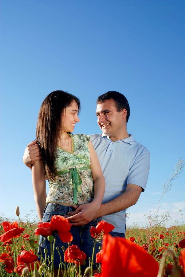 Young couple on a red poppies field