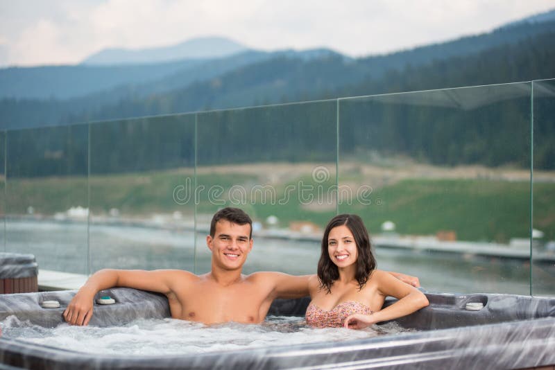 Young Couple Relaxing Enjoying Jacuzzi Hot Tub Bubble Bath Outdoor