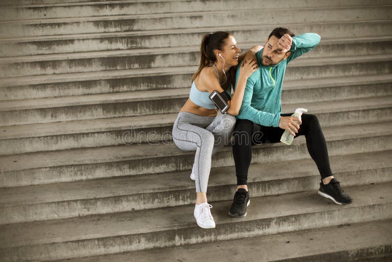 Young couple resting during training with bottle of water stock image