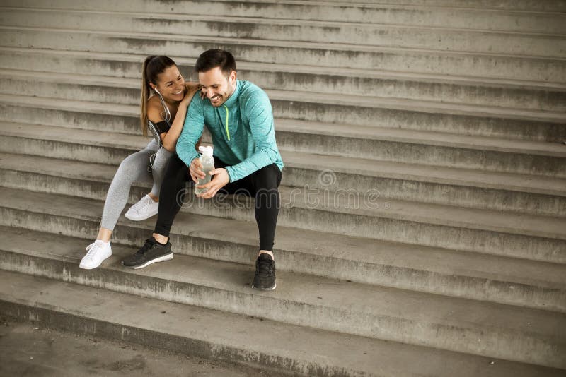 Young couple resting during training with bottle of water stock photo