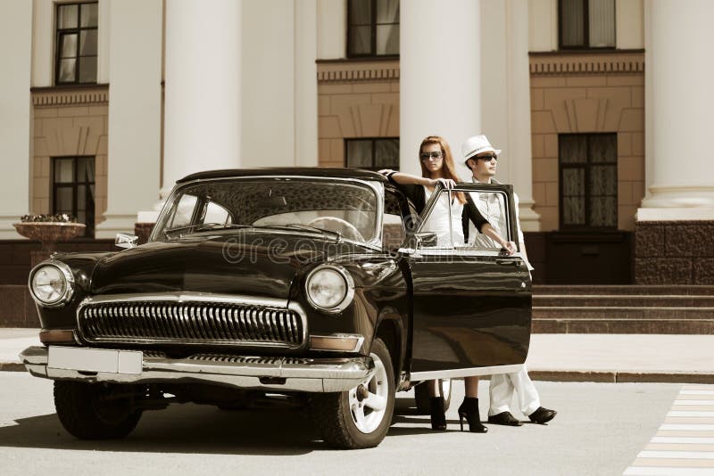 Young fashion couple at the retro car