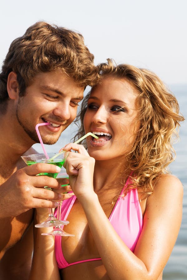 Young couple on the seaside with cocktails