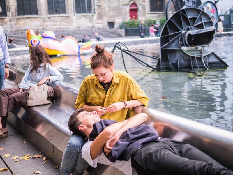 Young couple shares intimate moment at the Stravinsky Fountain, royalty free stock photo Young couple shares intimate moment at the Stravinsky Fountain, royalty free stock photo