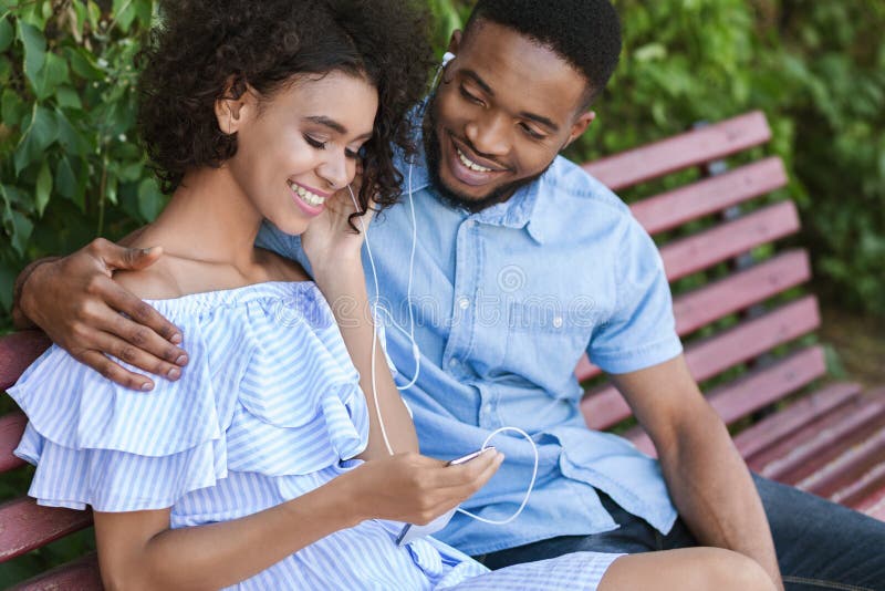 Young couple sitting on bench in park