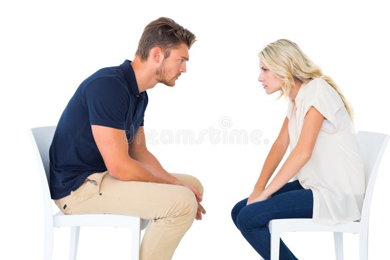 Young couple sitting in chairs arguing