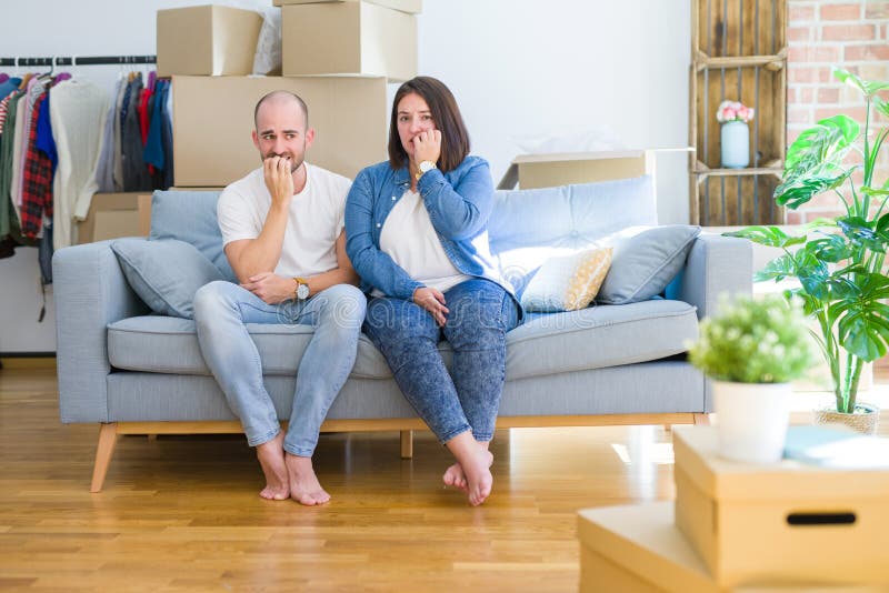 Young Couple Sitting on the Sofa Arround Cardboard Boxes Moving To a ...