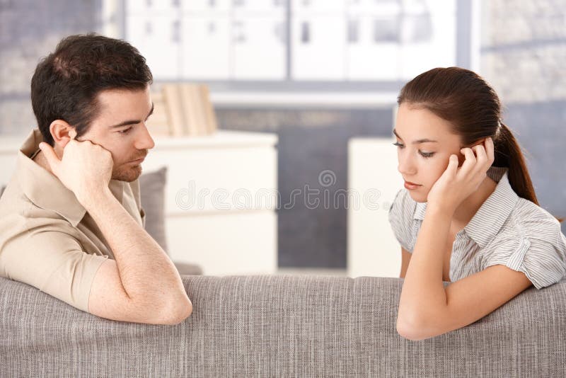 Young couple sitting on sofa sadly royalty free stock photo