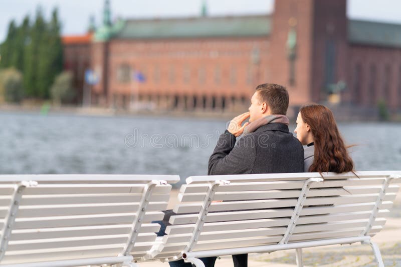 Young couple sitting on a waterfront bench royalty free stock image Young couple sitting on a waterfront bench royalty free stock image