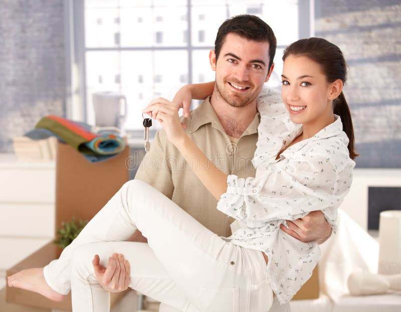 Young couple smiling happily in new house