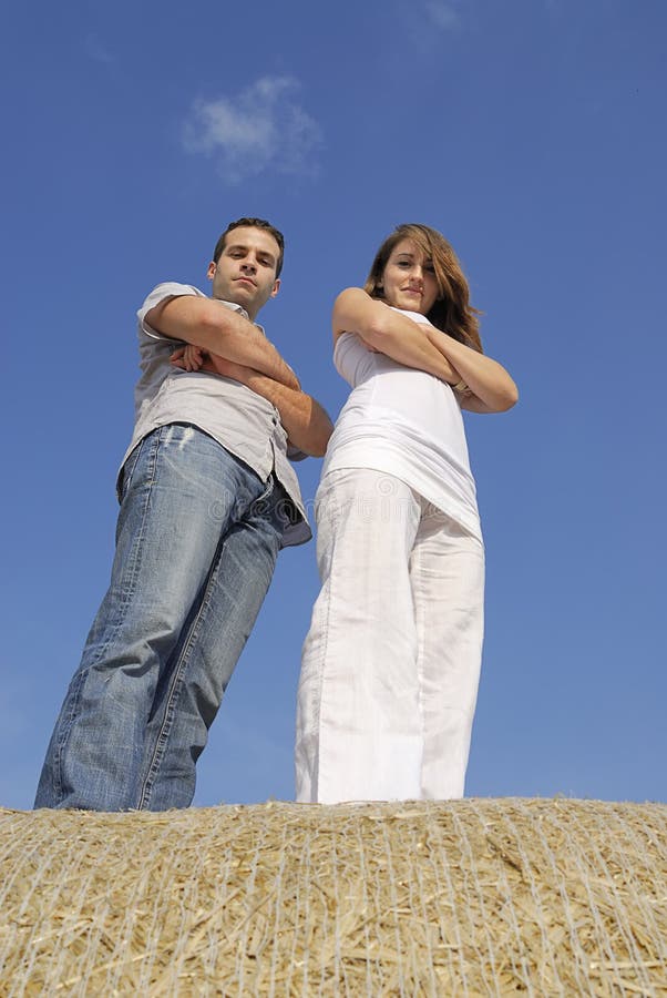 Young couple standing on a straw bale