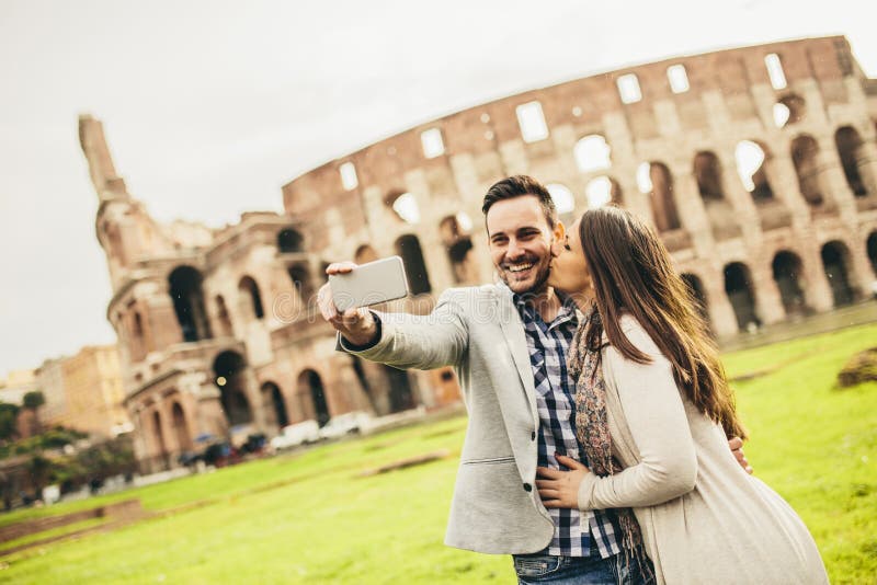 Young couple taking selfie in front of Colosseum in Rome, Italy stock photography Young couple taking selfie in front of Colosseum in Rome, Italy stock photography