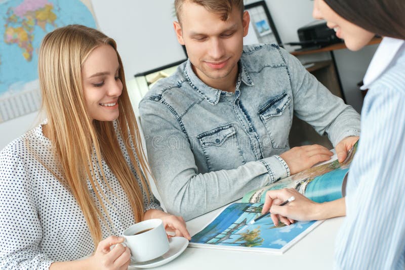Young couple in a tour agency communication with a travel agent travelling concept booklet royalty free stock images Young couple in a tour agency communication with a travel agent travelling concept booklet royalty free stock images