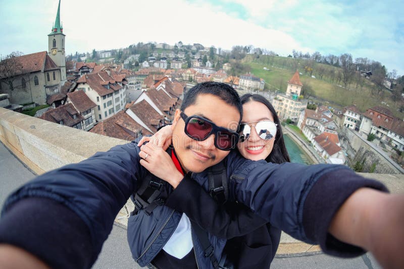 A Young Couple Tourists selfie with mobile phone near old town in Bern at Switzerland. A Young Couple Tourists selfie with mobile phone near old town in Bern at Switzerland