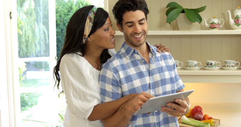 Young couple using digital tablet in kitchen