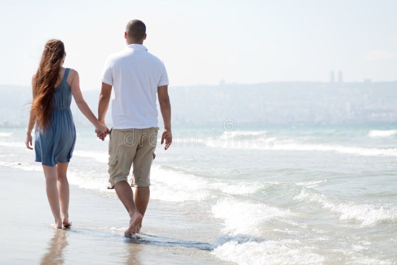 Young couple walk at the beach