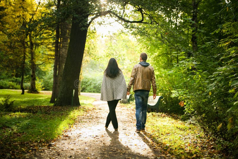 Young couple walking in a fall park royalty free stock photo