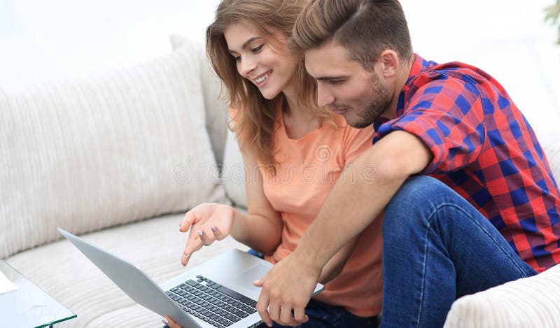 Young couple watching videos on laptop