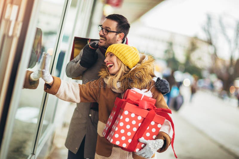 Couple window shopping on a winter day, looking for a Christmas gifts stock images Couple window shopping on a winter day, looking for a Christmas gifts stock images