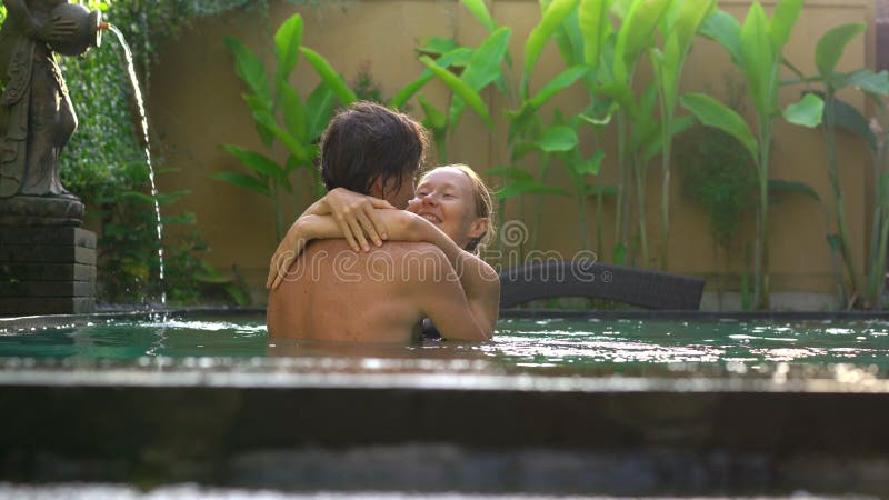 Young couple woman and man have fun in their private swimming pool. Honeymoon concept