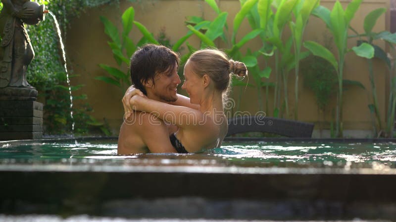 Young couple woman and man have fun in their private swimming pool. Honeymoon concept